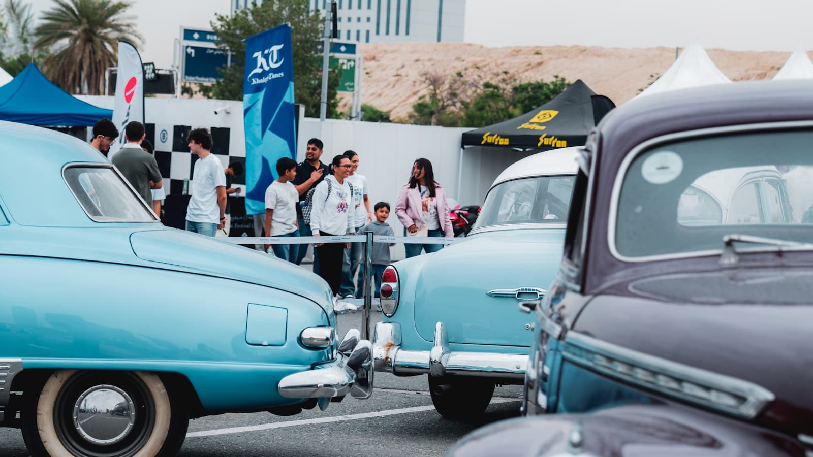Vintage cars lined up at an outdoor car show